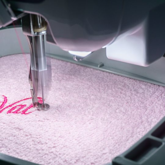 Close,Up,Images,Of,Embroidery,Machine,Embroidering,On,Pink,Towel